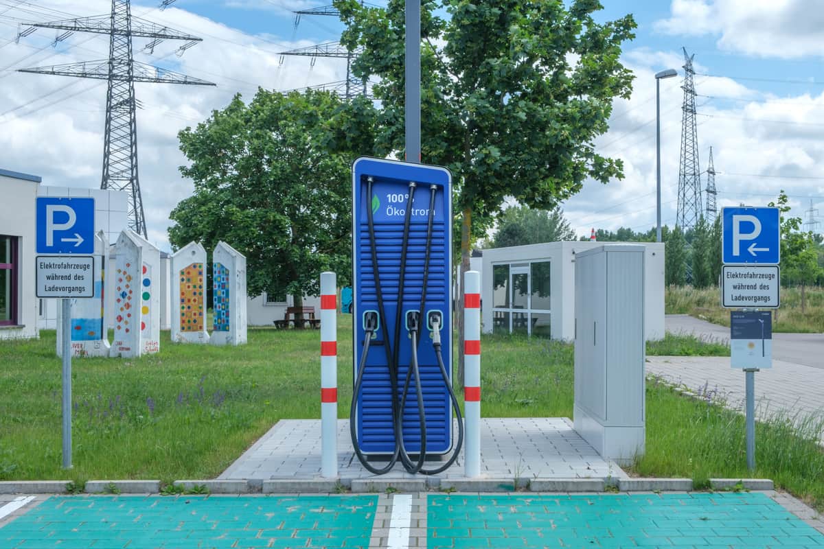 A coiled EV charging cable and connector on a light background